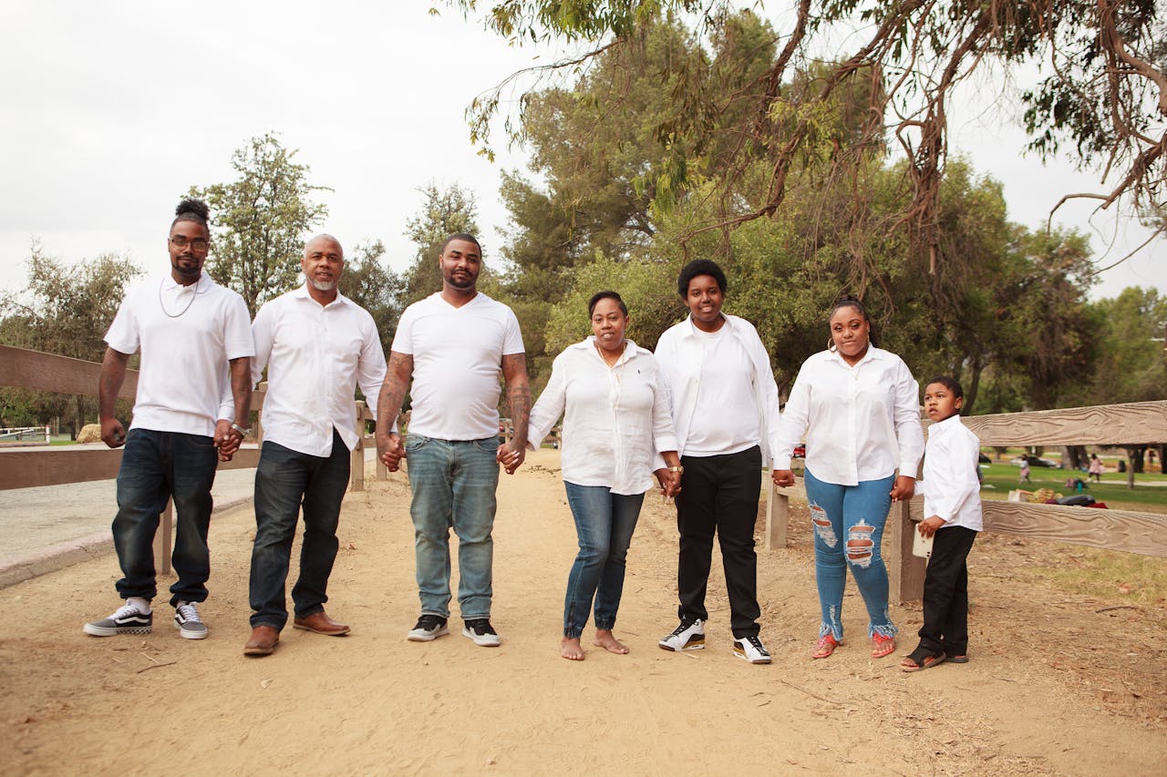 Crafting Captivating Headlines: Your awesome post title goes here A happy family of seven holding hands in a park, dressed in matching outfits.