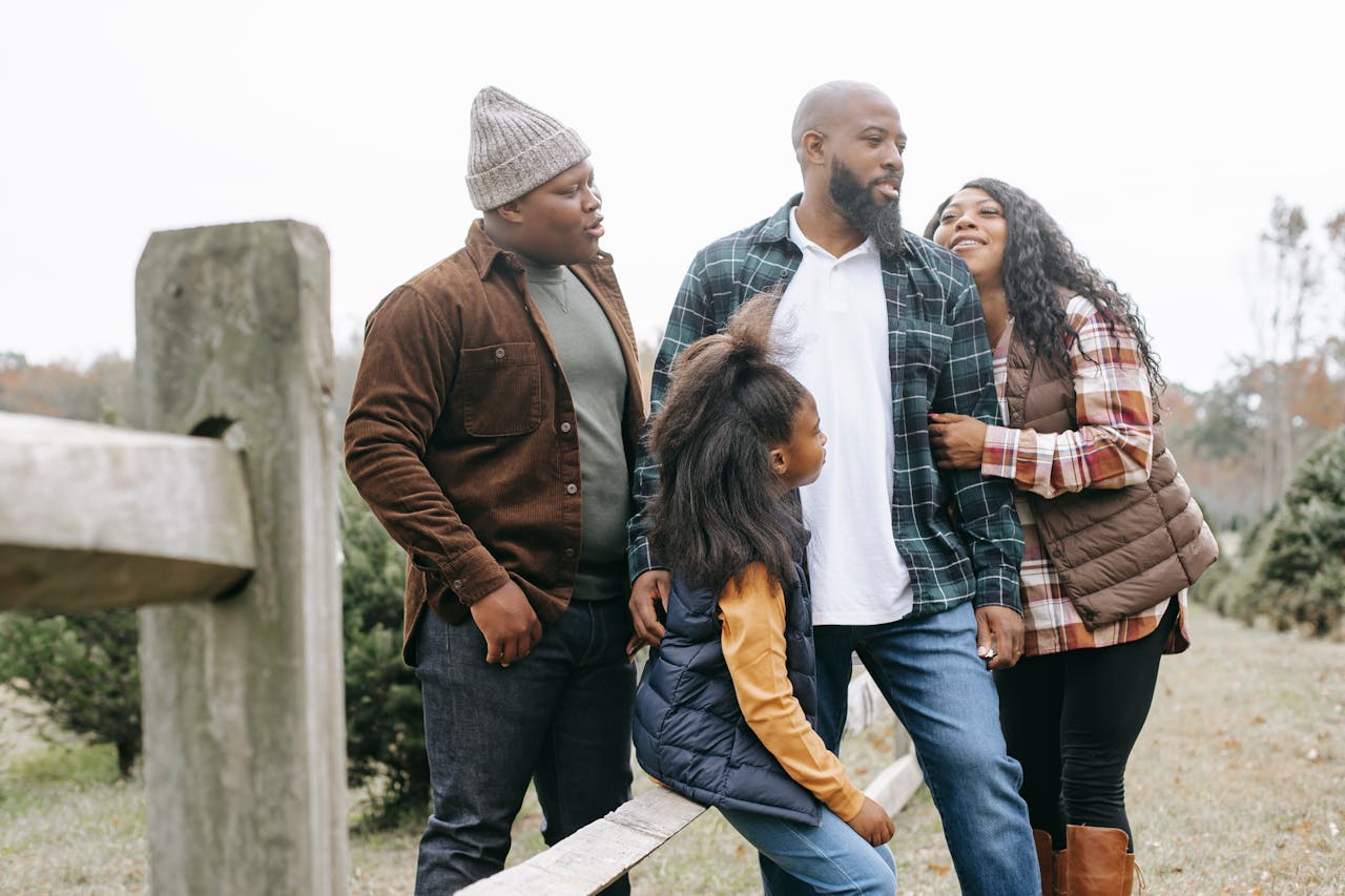 The Art of Drawing Readers In: Your attractive post title goes here Young black parents with son and daughter interacting near wooden fence in countryside under white sky